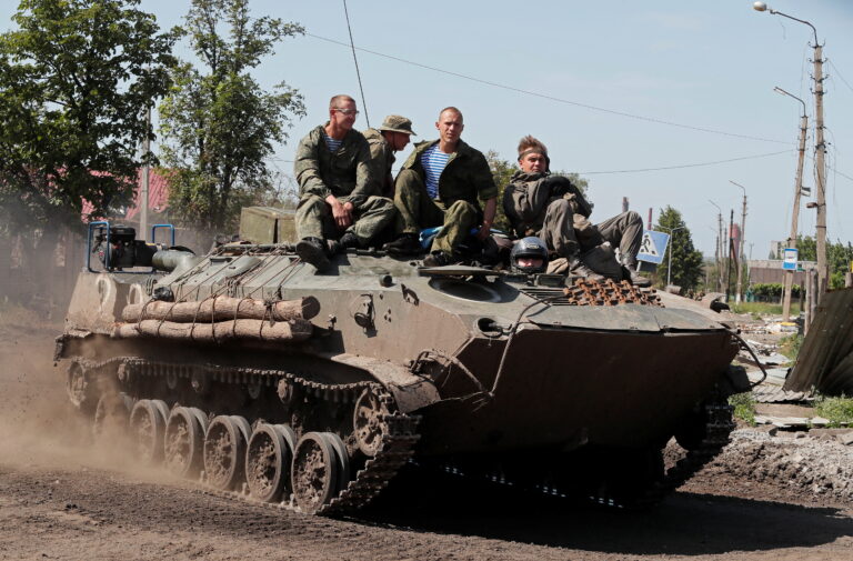 Service members of pro-Russian troops drive an armoured personnel carrier in Popasna